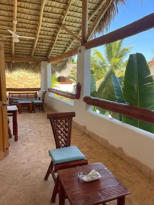 a patio with tables and chairs and a large window at Guest-Room 1 Palmeras - 3 Pax, 5 Min de La Playa in Las Galeras