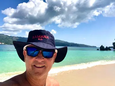 a man wearing a hat and sunglasses on the beach at Villa KAMBUSA appartamento SOFIA in Las Galeras