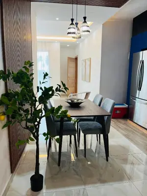 a dining room table with chairs and a potted plant at The Beauty and The Beach in Nagua