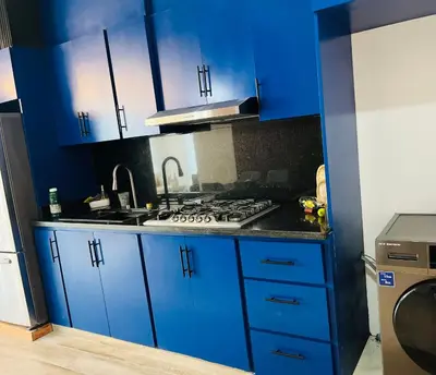 a kitchen with blue cabinets and a stove top oven at The Beauty and The Beach in Nagua