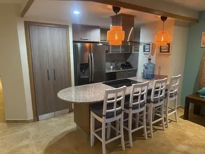 a kitchen with a counter and a island with bar stools at Juan Dolio Beach, Marbella Ocean Front in Colorado