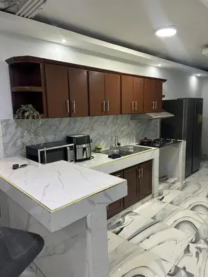 a kitchen with white marble floors and wooden cabinets at Apartamento Oasis in La Caleta