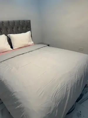 a large white bed with a headboard and white pillows at Apartamento Oasis in La Caleta