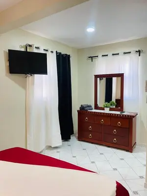 a bedroom with a bed and a dresser with a mirror at De pina apartaestudio in Santiago de los Caballeros