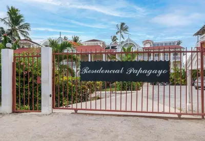 a gate with a sign on it in front of a building at Oceanfront apartment in Las Terrenas