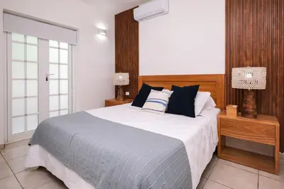 a bedroom with a large bed with blue and white pillows at Oceanfront apartment in Las Terrenas