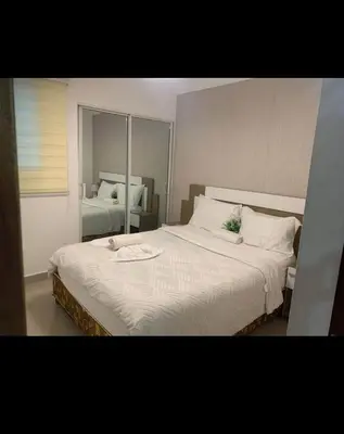 a bedroom with two beds with white sheets and a mirror at Leni's Confort in Santiago de los Caballeros
