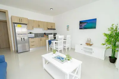 a living room with a kitchen and a table at Tranquil 2BR Retreat in Sunshine Bayahibe in San Rafael del Yuma