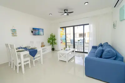 a living room with a blue couch and a table at Tranquil 2BR Retreat in Sunshine Bayahibe in San Rafael del Yuma