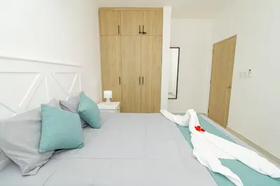 a bedroom with a bed with blue and white pillows at Tranquil 2BR Retreat in Sunshine Bayahibe in San Rafael del Yuma