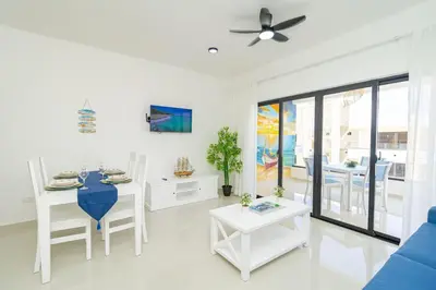 a white living room with a table and chairs at Tranquil 2BR Retreat in Sunshine Bayahibe in San Rafael del Yuma
