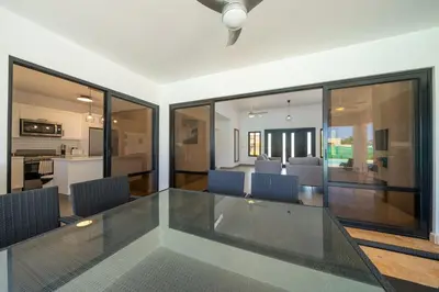 a dining room with a glass table and chairs at Location , Vibe , Style in Sosúa
