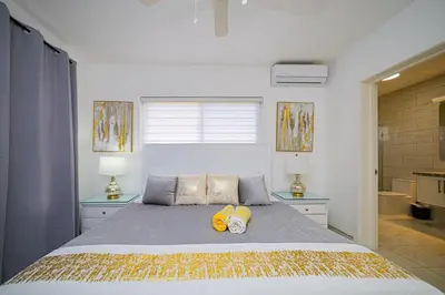 a bedroom with a bed with two yellow shoes on it at Luxury Villa, Garden View and Private Pool in La Mulata