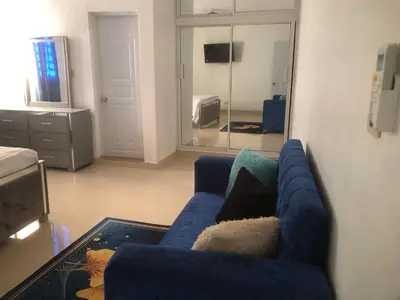 a living room with a blue couch and a mirror at Apartamento de lujo amueblado Guadeca B in Juan López