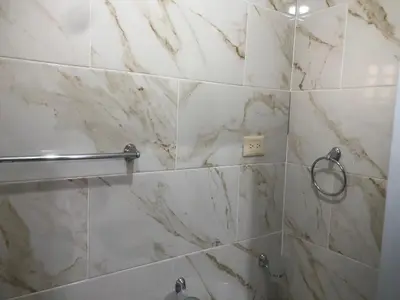 a bathroom with white marble walls and a shower at Apartamento de lujo amueblado Guadeca B in Juan López