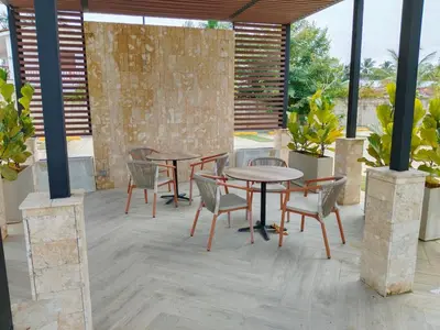 two tables and chairs on a patio with plants at Prado Suites Las Terrenas in Las Terrenas