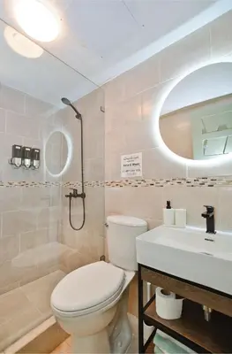 a bathroom with a toilet and a sink and a mirror at Tropical Retreat in El Cortecito beach condo in Punta Cana