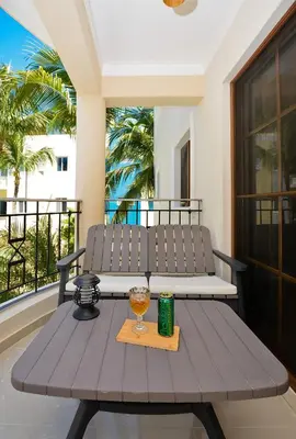 a wooden table with a glass of wine on a balcony at Tropical Retreat in El Cortecito beach condo in Punta Cana