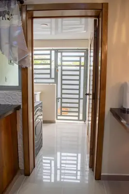 an open door to a kitchen with a refrigerator at Luxury Apartment in San Pedro de Macorís