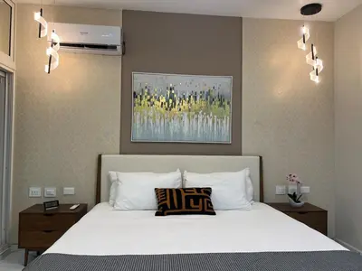 a bedroom with a white bed with two pillows at Santana Building in San Pedro de Macorís