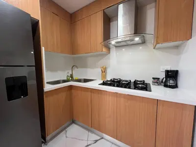 a kitchen with wooden cabinets and a stove top oven at Santana Building in San Pedro de Macorís