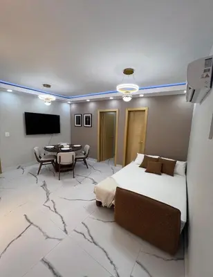 a bedroom with a bed and a table and a tv at Santana Building in San Pedro de Macorís
