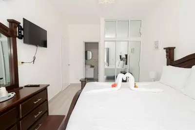 a bedroom with a white bed with a tv on it at Bright 2BR Apartment with Pool near Bayahibe Beach in San Rafael del Yuma