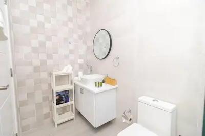 a white bathroom with a sink and a mirror at Bright 2BR Apartment with Pool near Bayahibe Beach in San Rafael del Yuma