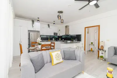a living room with a couch and a kitchen at Bright 2BR Apartment with Pool near Bayahibe Beach in San Rafael del Yuma