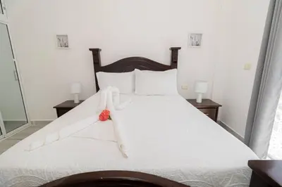 a bedroom with a white bed with a red bow on it at Bright 2BR Apartment with Pool near Bayahibe Beach in San Rafael del Yuma