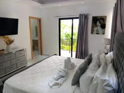 a bedroom with a bed with white shoes on it at Casahermosa in Santo Domingo