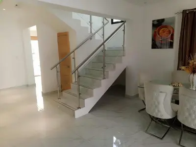 a staircase in a living room with a table and chairs at Casahermosa in Santo Domingo