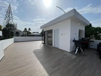 a white house with a deck with a piano at Casahermosa in Santo Domingo