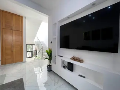 a living room with a large flat screen tv on a wall at Casahermosa in Santo Domingo