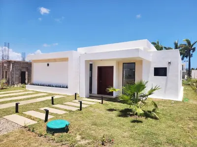 a white house with a green frisbee in the yard at Villa in SOV, close to Santa Fe in Sosúa