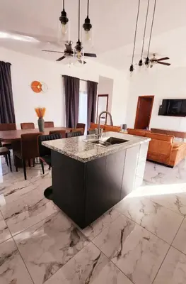 a kitchen with a marble counter top and a table at Villa in SOV, close to Santa Fe in Sosúa