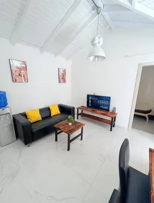 a living room with a black couch and a table at Colina Buena Vista VIP in Jarabacoa
