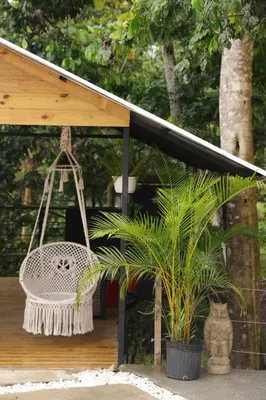 a hammock hanging from a porch with a plant at Casa Loma, Descansar en la Montaña, 30min STG in La Búcara