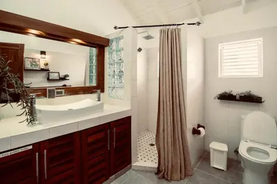a bathroom with a sink and a toilet and a mirror at Sole E Mare Beach House in Las Terrenas