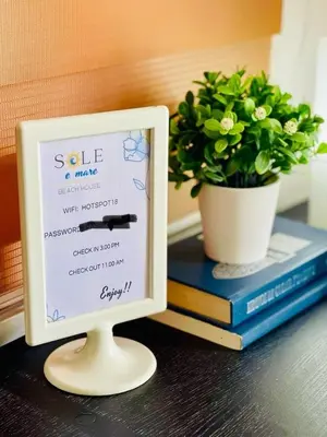 a sign on a table next to a potted plant at Sole E Mare Beach House in Las Terrenas
