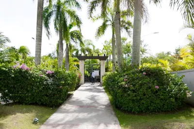 a walkway in a park with palm trees and flowers at Lujoso Pent-house en el Residencial Mediterráneo in Santiago de los Caballeros
