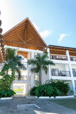 a building with palm trees in front of it at Residencial Esprit Caribbean in Bayahibe
