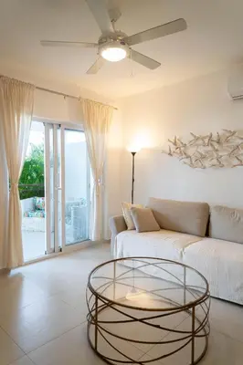 a living room with a couch and a glass table at Residencial Esprit Caribbean in Bayahibe