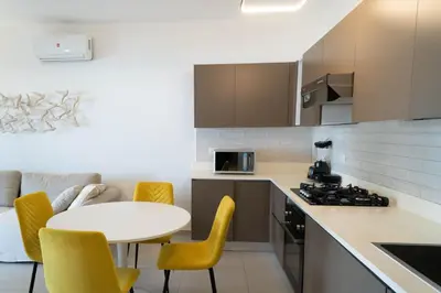 a kitchen with a white table and yellow chairs at Residencial Esprit Caribbean in Bayahibe