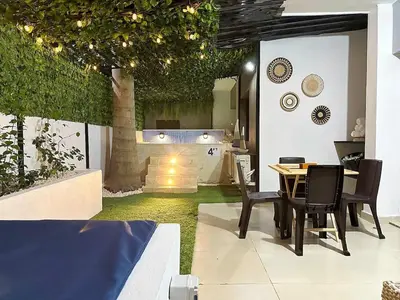 a dining room with a table and chairs and a garden at Luxury Apartment-Santiago- PRIVATE Jacuzzi & Patio-Near Airport in Santiago de los Caballeros