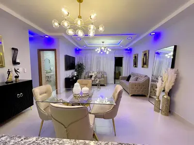 a living room with a glass table and chairs at Luxury Apartment- PRIVATE Patio & BBQ- Near Airport in Santiago de los Caballeros