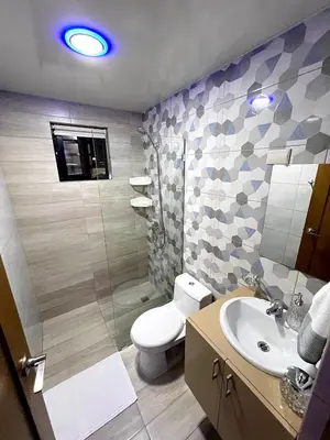 a bathroom with a toilet and a sink and a shower at Luxury Apartment- PRIVATE Patio & BBQ- Near Airport in Santiago de los Caballeros