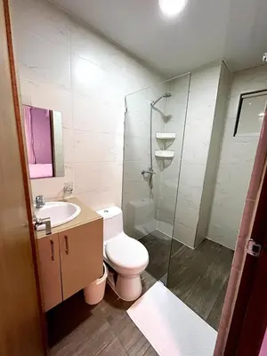 a bathroom with a toilet and a glass shower at Luxury Apartment- PRIVATE Patio & BBQ- Near Airport in Santiago de los Caballeros
