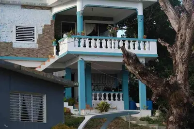 a blue and white house with a balcony at Bed-Breakfast lunch Tropical Private-room in Santa Bárbara de Samaná