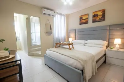 a bedroom with a large bed and a bathroom at Studio 3 Zona Colonial - Centro Histórico in Santo Domingo